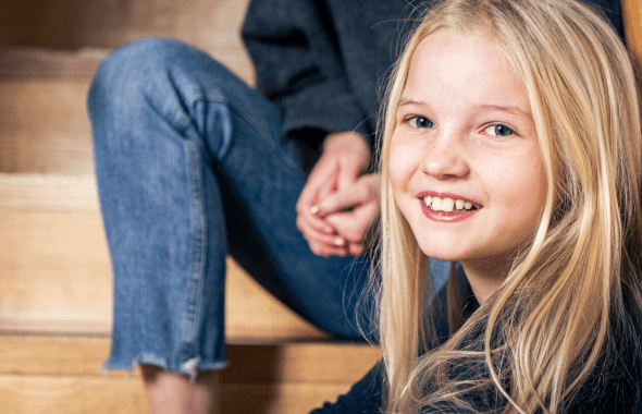 Porträtt flicka elev i skolan sitter i en trappa och lutar huvudet mot ledstången