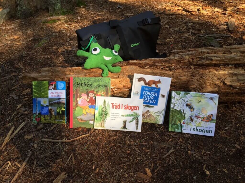 Ute-Ugo, en tygfigur i grönt, lärvän, ute i naturen med böcker,osmos öppna förskola